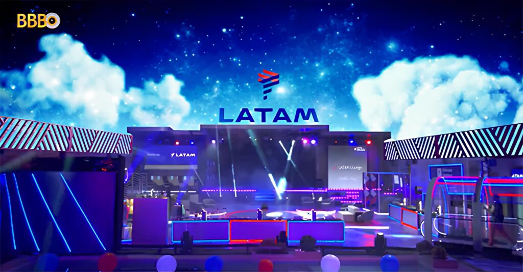 Nesta imagem, observa-se um palco com a logo da LATAM acima. Representa o patrocínio da empresa em uma festa deste ano e uma forma de divulgação da marca.